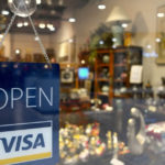 store with a Open Visa sign hanging on the door