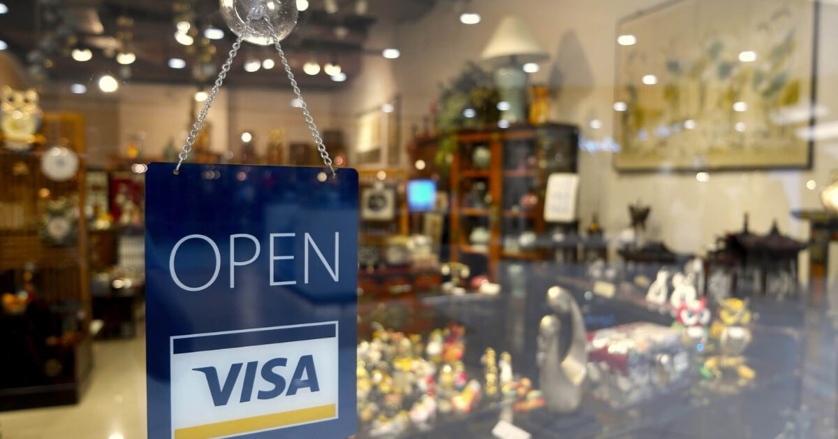 store with a Open Visa sign hanging on the door