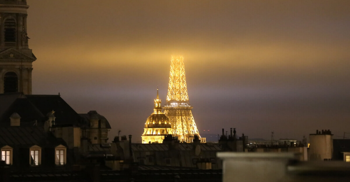 The Eiffel Tower with its top in the clouds and the dome of the Invalides