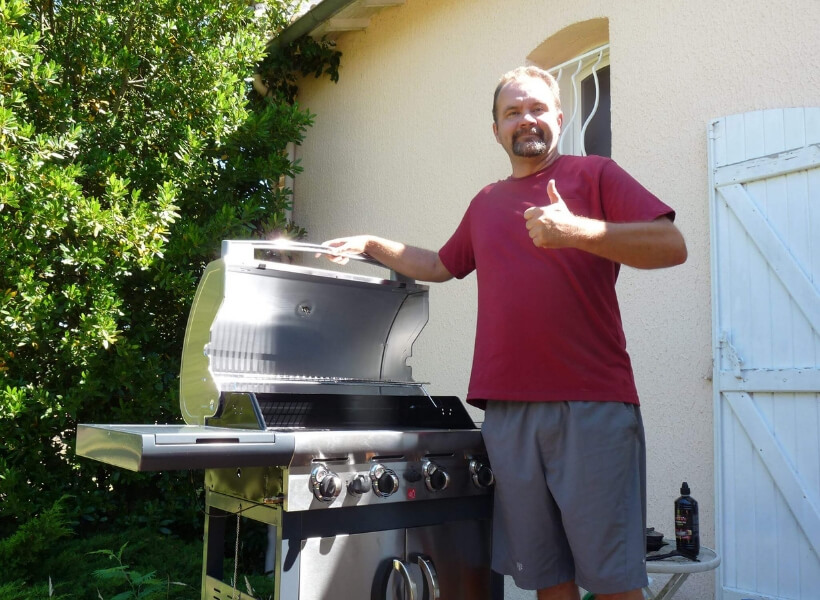 Todd Newman standing near his barbecue and doing the thumbs up sign