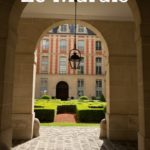 Rounded Stone Door Gateway that opens onto the characteristic brick pattern of the Place des Vosges in Paris