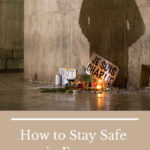 person paying respect in front of a "je suis charlie" sign: How to Stay Safe in France episode