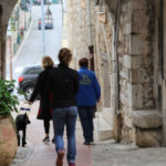 A womand and her guide dog walking through the streets of La Turbie in Provence