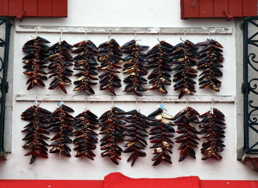 espelette peppers hung on the front of a house