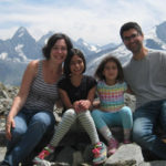 Matt, his wife and daughters in front of snowy mountains in the Alps. Provence and Chamonix episode.