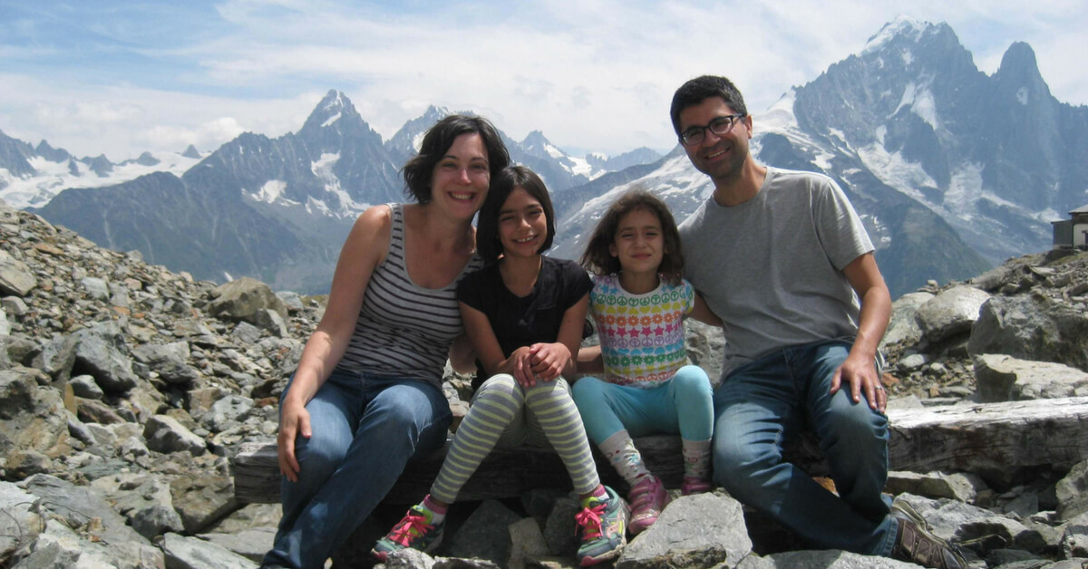 Matt, his wife and daughters in front of snowy mountains in the Alps. Provence and Chamonix episode.