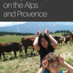Matt's daughter immitating the cows that are behind them by putting on horns with their fingers: Provence and Chamonix episode