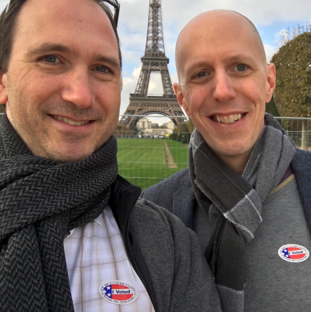 Mike August and his husband in front of the eiffel tower