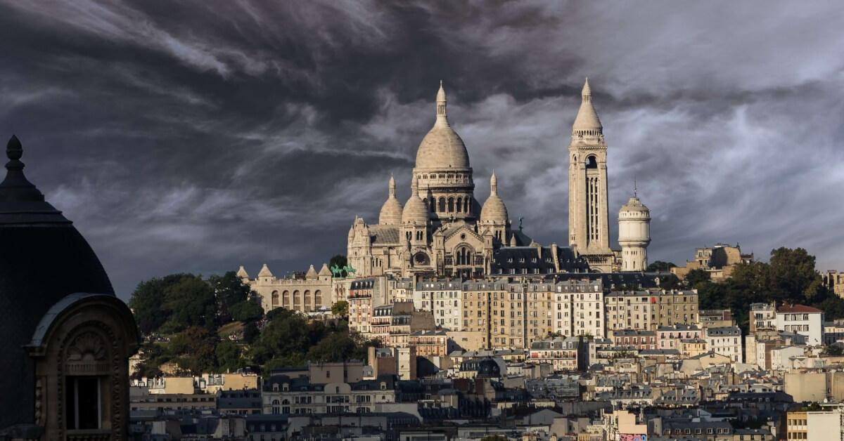 A view of Montmartre and the Sacré Coeur Basilica under a stormy sky