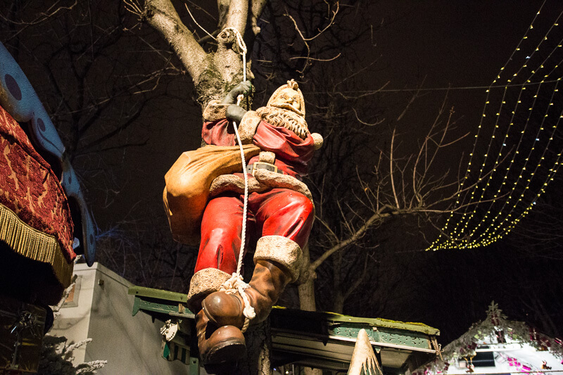 santa climbing down a rope at the paris christmas market