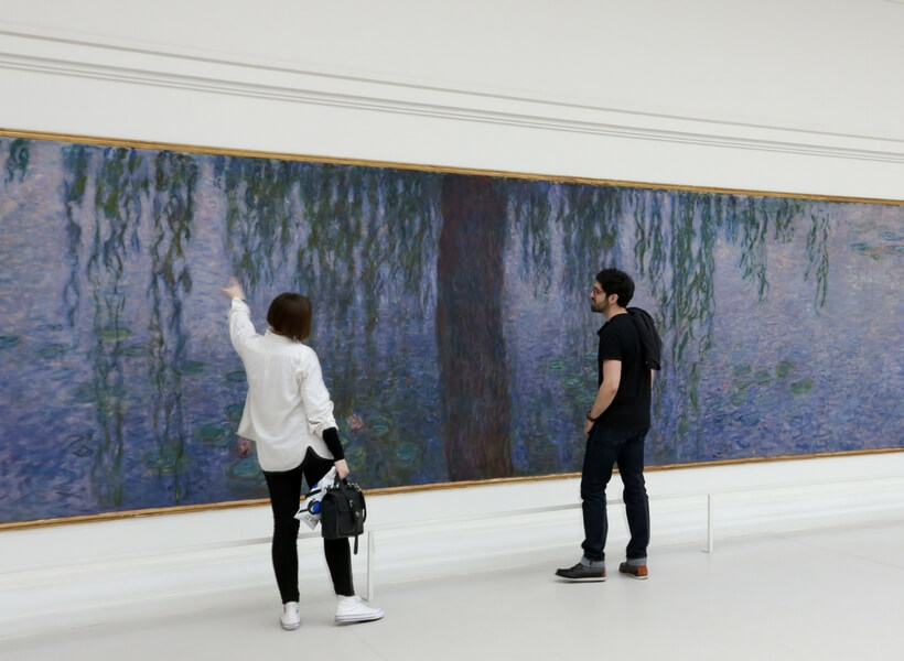 Visitors looking at the Water Lilies at the Orangerie Museum in Paris