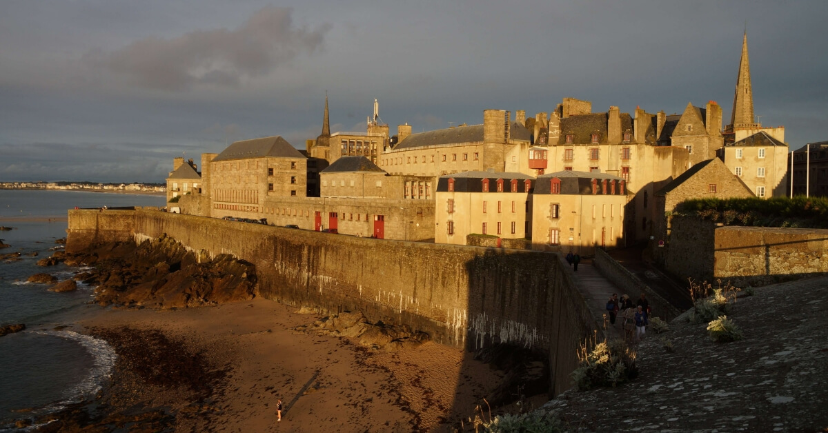 city of Saint-Malo at dusk showing the rampart walls mentioned in the book all the light we cannot see