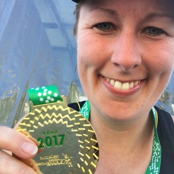 Calee holding her finisher's medal at the Paris Marathon