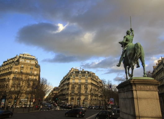 beautiful plaza in paris, statue of man on a horse, hausmanian buildings and dramatic sky