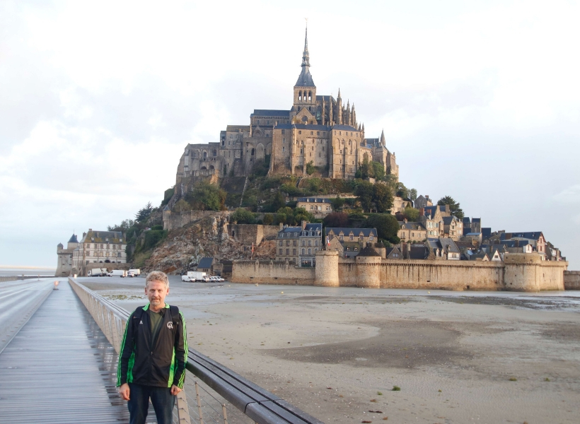 Phil Roberson standing in front of the Mont Saint Michel: Mont Saint Michel History Episode