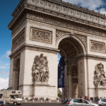 cars driving around the arc de triomphe in Paris