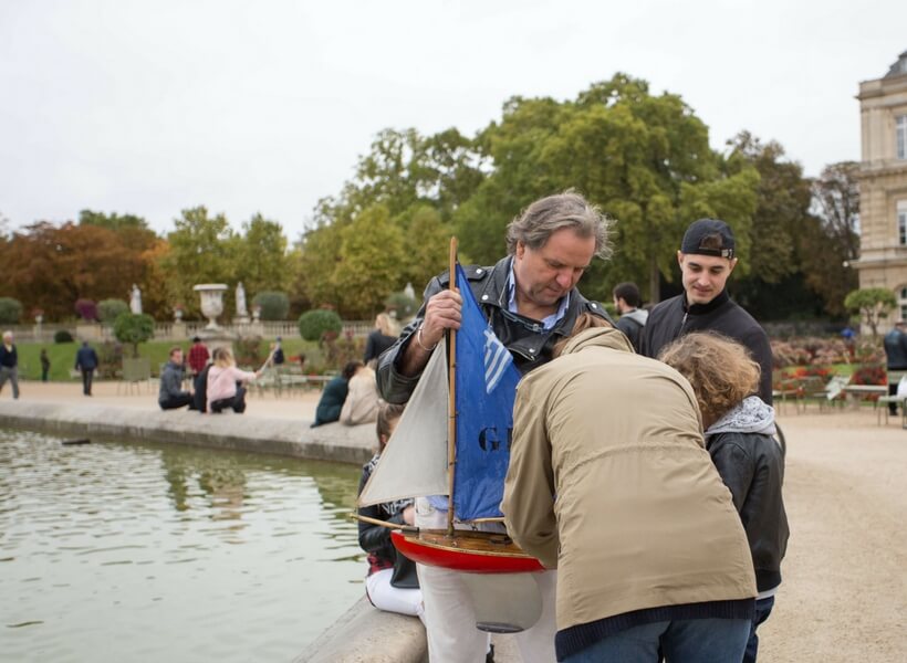 Men playing with toy boats at the Luxembourg Gardens