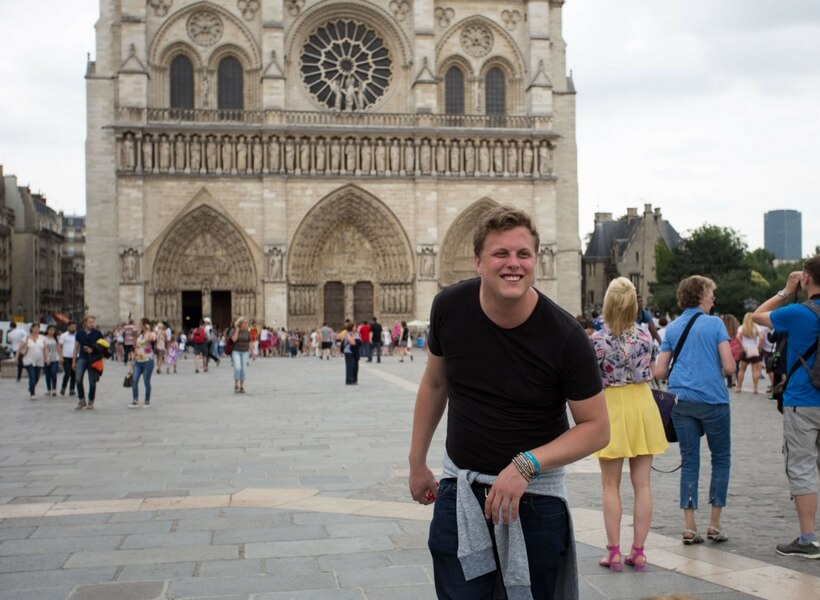 man imitating quasimodo in front of notre dame cathedral; how to do a layover in paris on your own