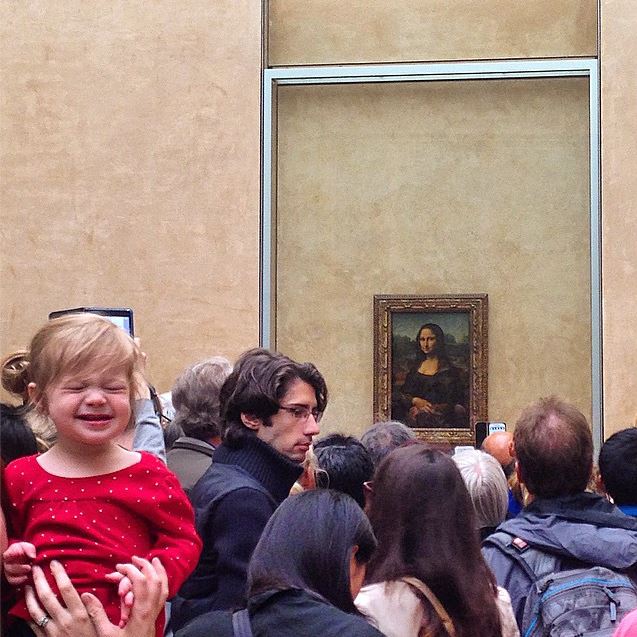 Crowd in front of the Mona Lisa with child making a face; layover in Paris