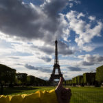 annie with thumbs up in front of the Eiffel Tower; layover in paris