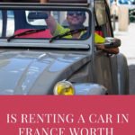man waving hello from inside his 2CV with a big grin on his face