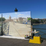 Artitst painting Paris while standing on the pont des arts: visiting paris in august episode