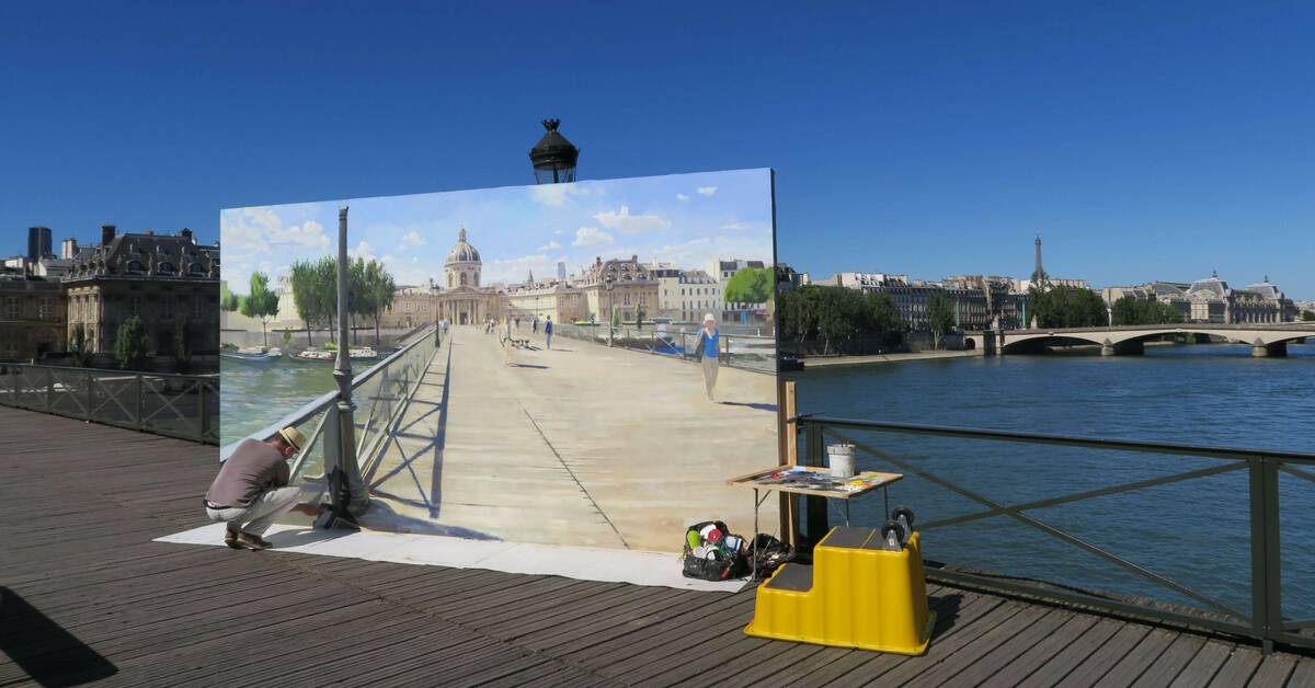 Artitst painting Paris while standing on the pont des arts: visiting paris in august episode
