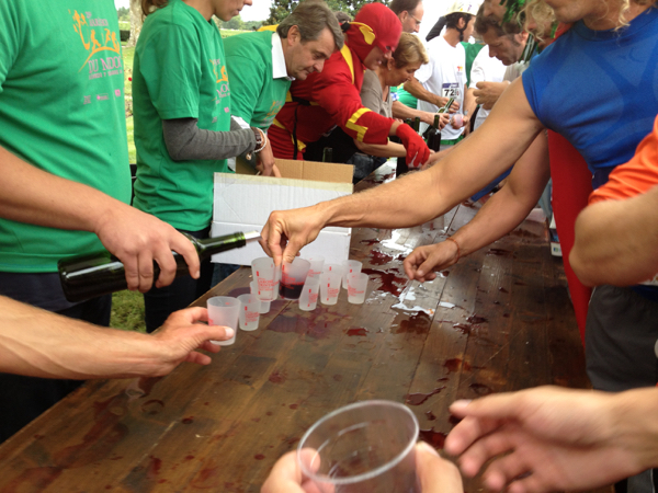 marathon runners getting a small glass of wine while running the bordeaux marathon