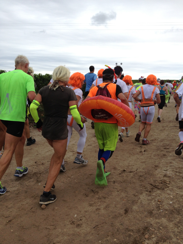 person running the Bordeaux marathon with a swimmer's life preserver and flippers on his feet