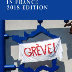 sculpture showing a cutout of France with a home-made white sheet sign opver it that says "grève" (strike)