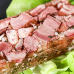 a plate of pâté de tête over a bed of lettuce