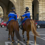 two police officers patroling on horseback in a Paris neighborhood