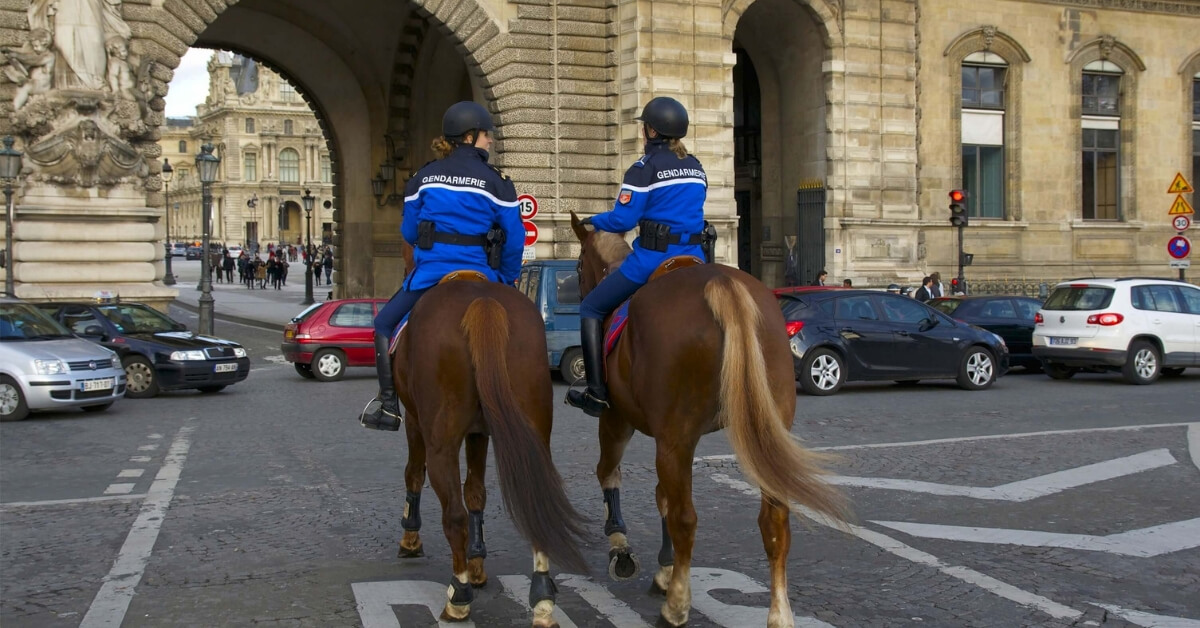 two police officers patroling on horseback in a Paris neighborhood