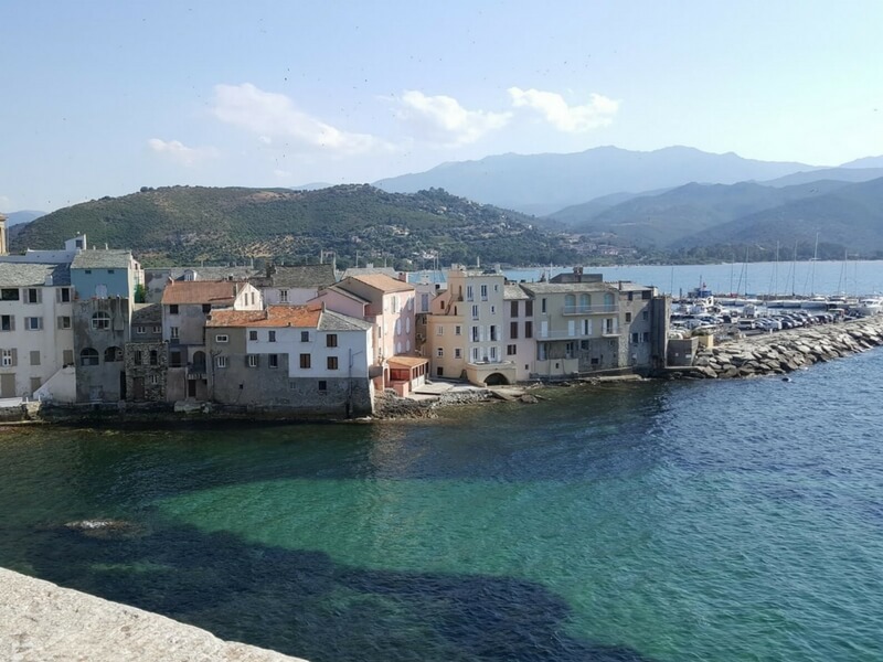 turquoise-green waters of the Mediterranean with a city in the background