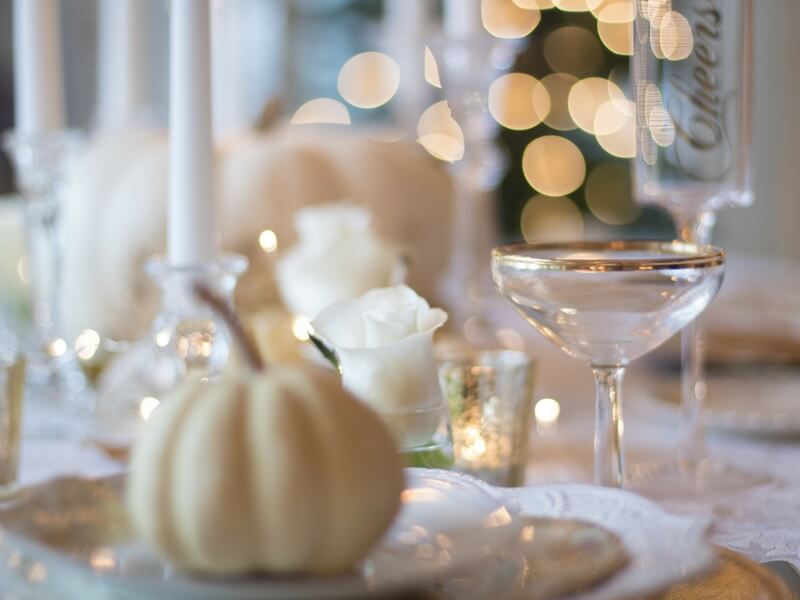 beautiful table decoration with a white squash, candles, and golden reflections