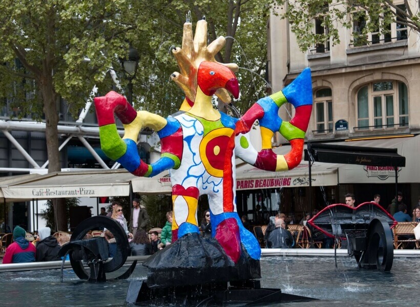 Large colorful rotating statue set in the middle of a large water fountain feature