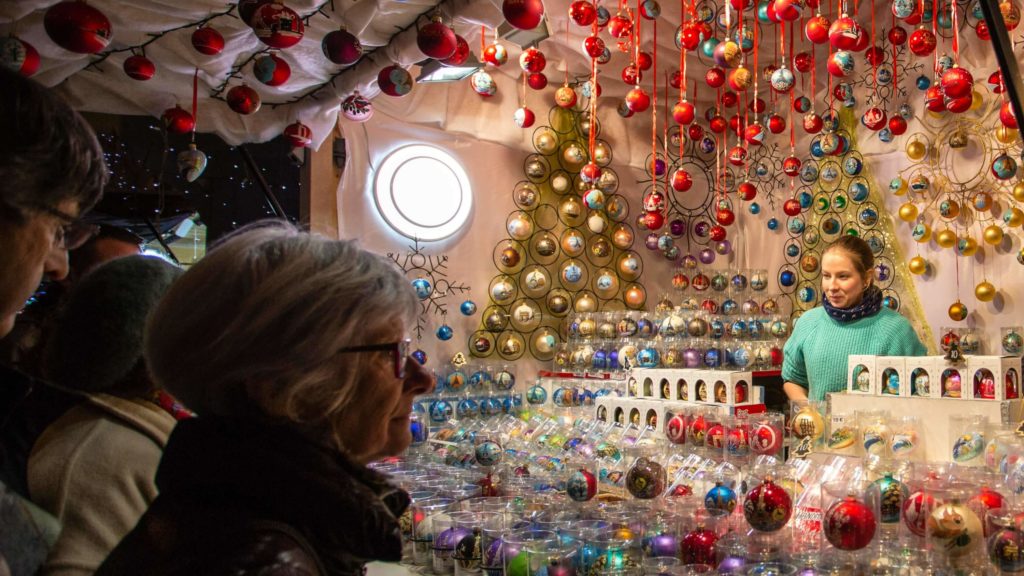 women standing in front of a store that sells christmas decorations at the paris christmas market on the champs elysees