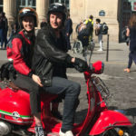 Oliver and his fiancée riding their red scooter in Paris