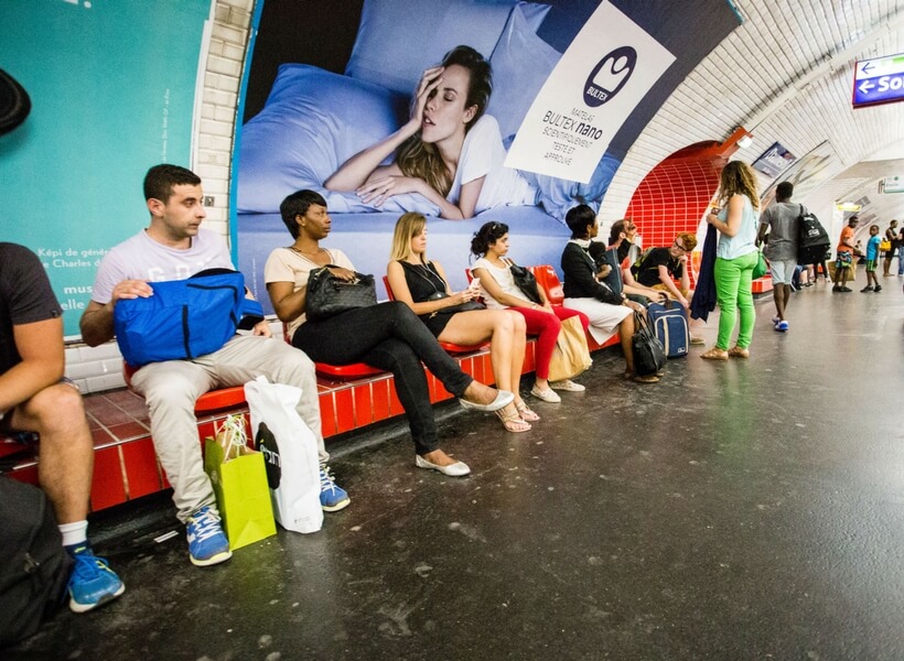 french people sitting in the metro while waiting for their train