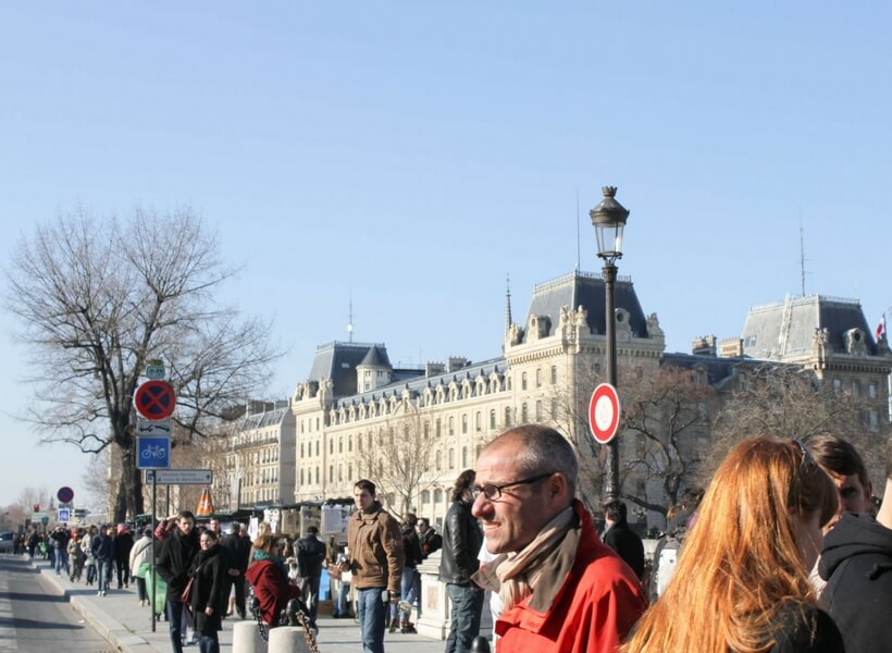 street photography in Paris: man wearing a red coat and a scarf and many other people wearing jeans and coats