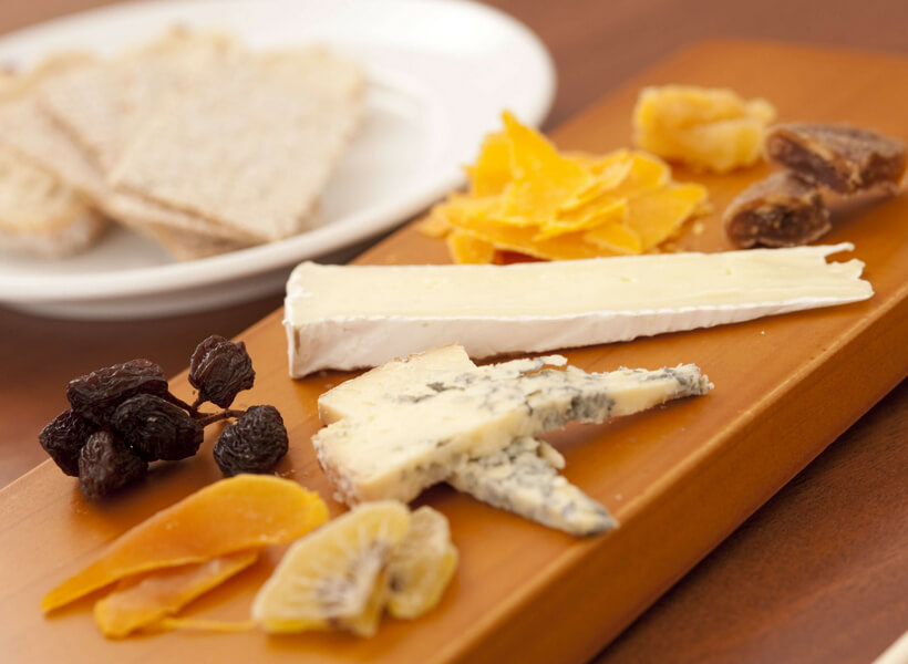 cheese platter with various slivers of cheese and crackers