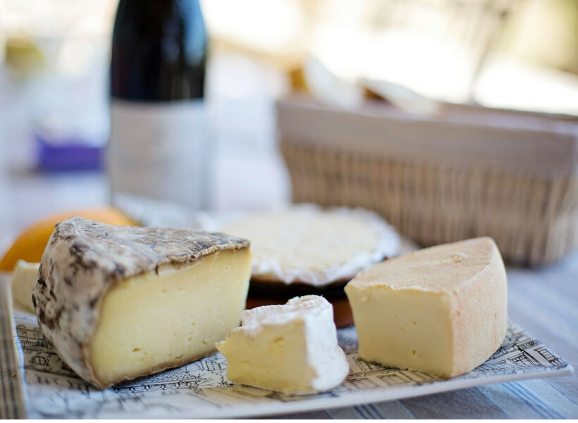 Cheese platter with a wine bottle and a bread basket