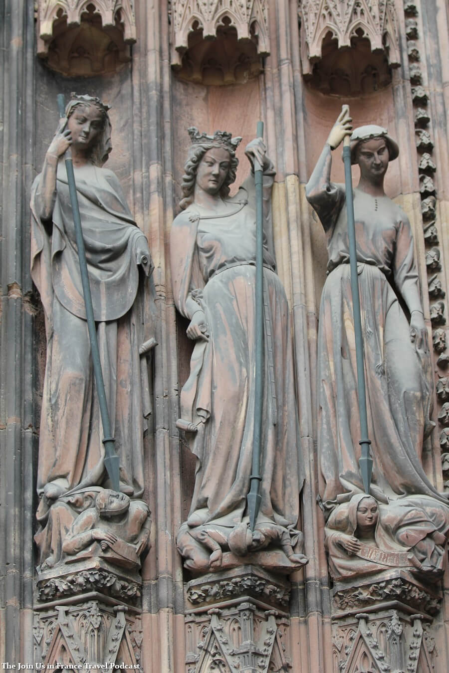 Statue of 3 women carrying spears outside of the Strasbourg Cathedral