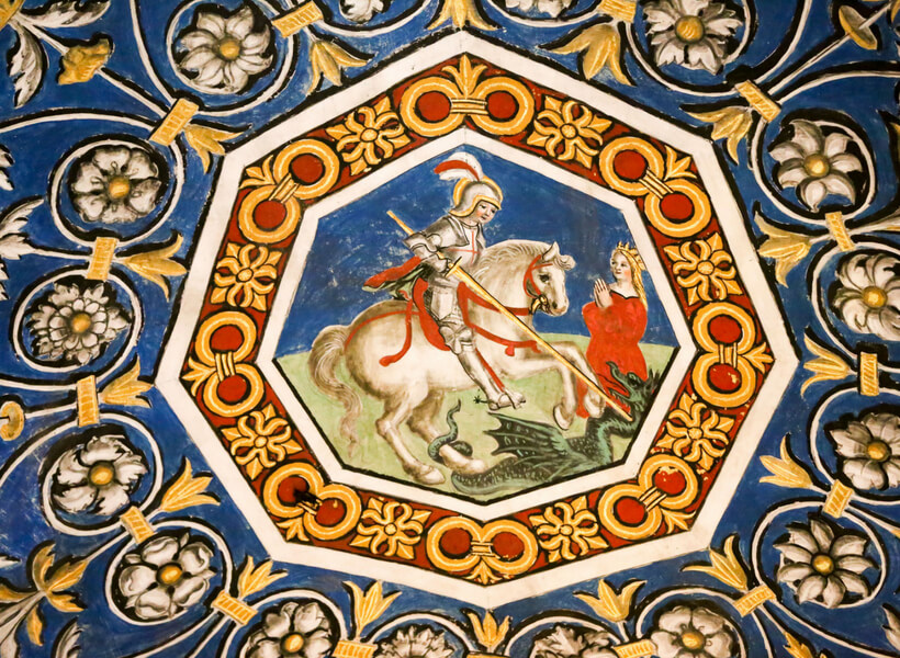 Detail on the cieling of the Albi Cathedral: armored man on a horse kills a dragon while a woman with a crown watches