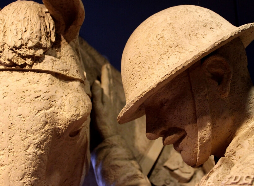 Detail of a memorial that shows a soldier wearing a helmet and his horse