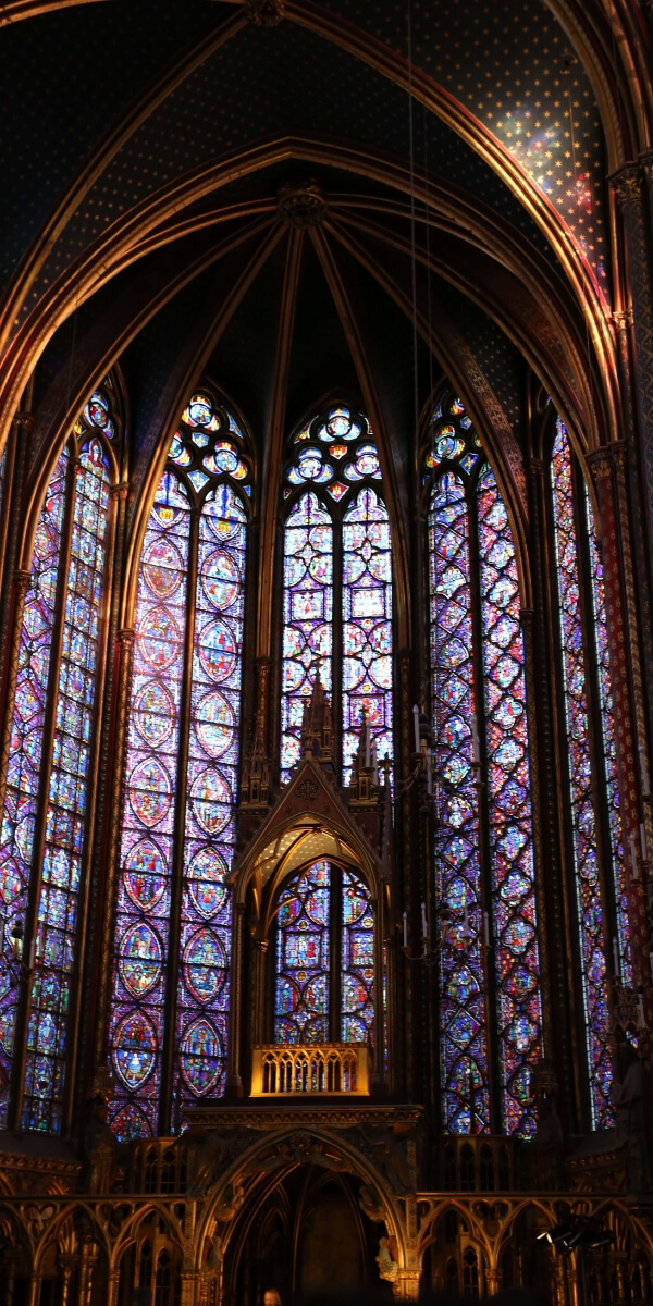 several panels of stained-glass windows at the Sainte Chapelle in Paris including beautiful light reflections on the stone