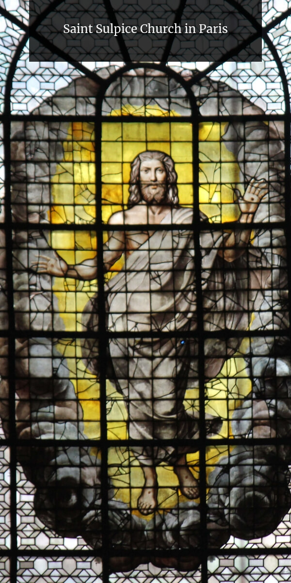 renaissance stained-glass with a large Jesus surrounded by yellow glass at Saint-Sulpice church in Paris