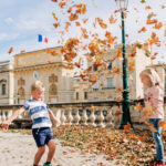 Boy and girl playing with dead leaves in the Tuileries garden: vacation photos episode