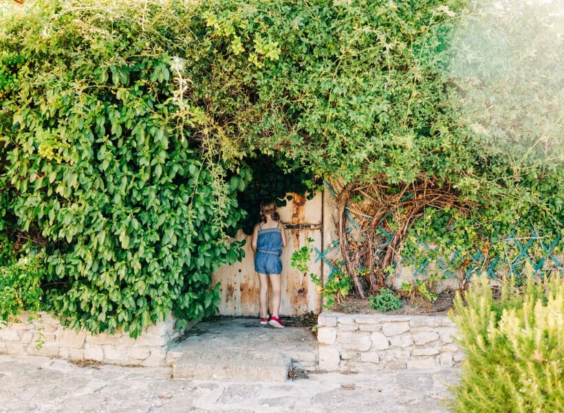 we see the back of a girl, she is standing in front of a beautiful door: vacation photos