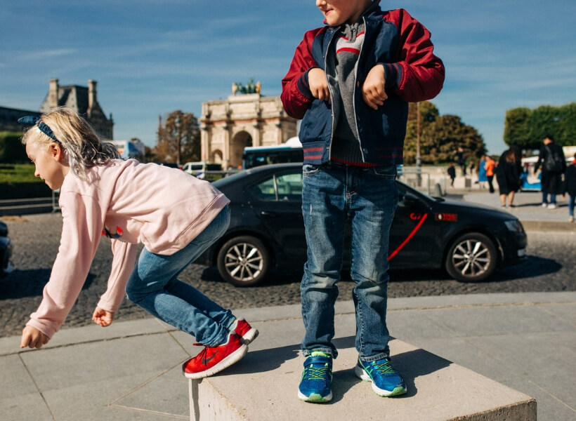 Boy and girl jumping off a block of cement and acting silly: vacation photos episode